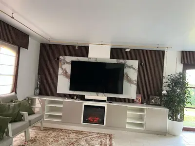 a living room with a flat screen tv on a entertainment center at Villa op de hoek Rooms in Aalst