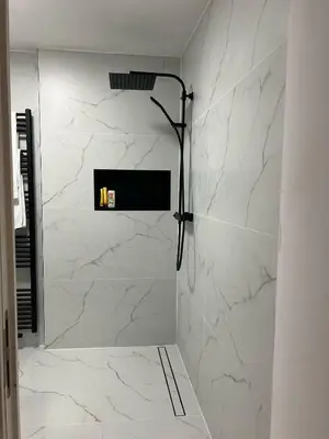 a bathroom with a shower with white marble walls at Villa op de hoek Rooms in Aalst