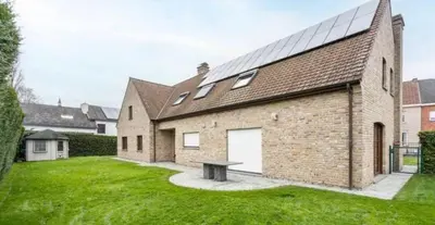 a brick house with a bench in the yard at Villa op de hoek Rooms in Aalst