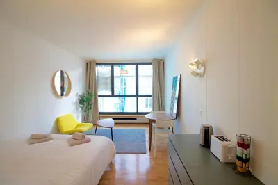 a bedroom with a bed and a yellow chair in it at Beautiful and bright apt AvLouise in Brussels