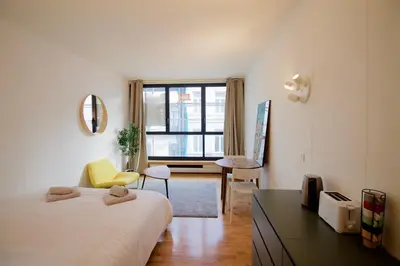 a bedroom with a bed and a desk with a yellow chair at Beautiful and bright apt AvLouise in Brussels