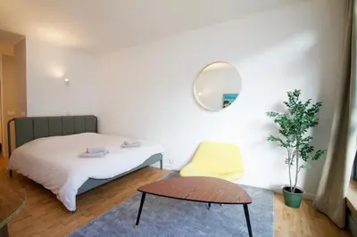a bedroom with a bed and a chair and a mirror at Beautiful and bright apt AvLouise in Brussels