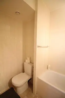 a white bathroom with a toilet and a bath tub at Beautiful and bright apt AvLouise in Brussels
