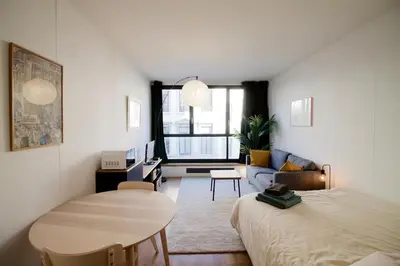 a bedroom with a bed and a table and a couch at Brand new & cosy - Louise & Stéphanie area in Brussels