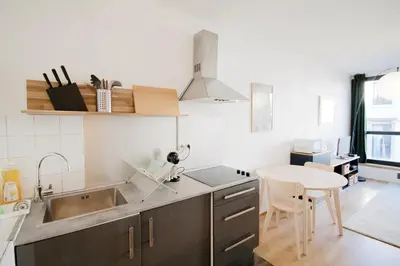 a kitchen with a sink and a counter with a table at Brand new & cosy - Louise & Stéphanie area in Brussels