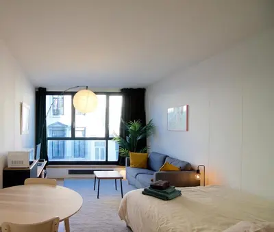 a room with a bed and a couch and a window at Brand new & cosy - Louise & Stéphanie area in Brussels