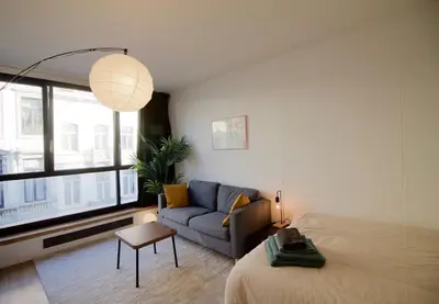 a room with a bed and a couch and a window at Brand new & cosy - Louise & Stéphanie area in Brussels