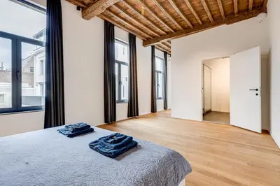 a bedroom with a bed with two blue towels on it at Beautiful spacious Loft in the Heart of Antwerp in Antwerp