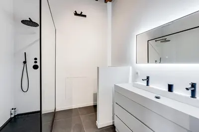 a white bathroom with a sink and a mirror at Beautiful spacious Loft in the Heart of Antwerp in Antwerp