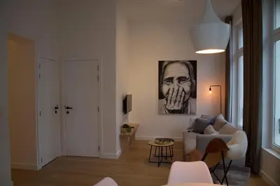 a living room with a couch and a painting on the wall at Charming Apartment with Cathedral View in Antwerp on the 2th floor in Antwerp