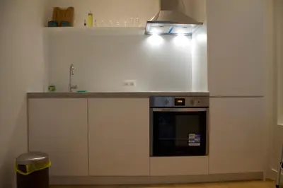 a kitchen with white cabinets and a stove top oven at Charming Apartment with Cathedral View in Antwerp on the 2th floor in Antwerp