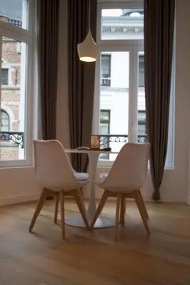 a dining room table and two chairs in front of a window at Charming Apartment with Cathedral View in Antwerp on the 2th floor in Antwerp