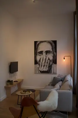 a living room with a couch and a drawing on the wall at Charming Apartment with Cathedral View in Antwerp on the 2th floor in Antwerp