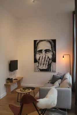 a living room with a couch and a painting on the wall at Charming Apartment with Cathedral View in Antwerp on the 2th floor in Antwerp
