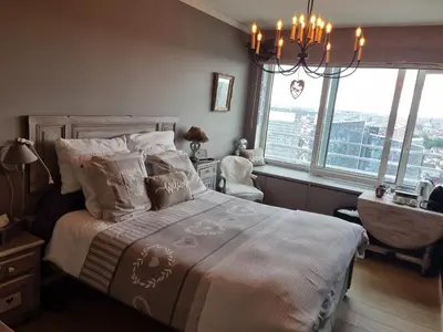 a bedroom with a bed with a chandelier and windows at Romantics rooms in Brussels sky in Brussels