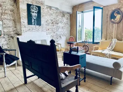 a living room with a bed and a couch at The Lofty Mystic's Lodge in Antwerp
