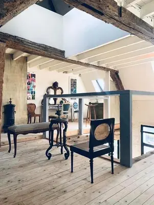 a room with a table and a chair on a wooden floor at The Lofty Mystic's Lodge in Antwerp