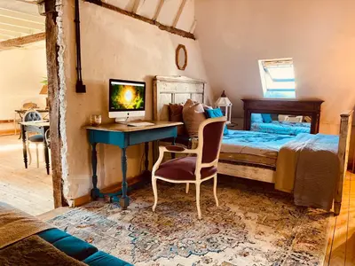 a bedroom with a bed and a desk with a computer at The Lofty Mystic's Lodge in Antwerp