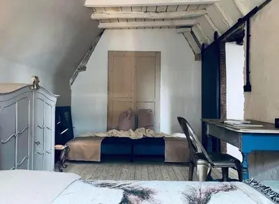 a bedroom with a bed and a desk and a chair at The Lofty Mystic's Lodge in Antwerp