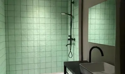 a bathroom with a shower with a sink and a mirror at The Lofty Mystic's Lodge in Antwerp