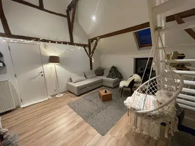 a living room with a couch and a swing at Petit duplex cosy coup de coeur, dans ferme de charme du 18 è siècle au milieu des champs in Bossut-Gottechain