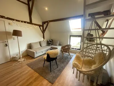 a living room with a couch and a chair at Petit duplex cosy coup de coeur, dans ferme de charme du 18 è siècle au milieu des champs in Bossut-Gottechain