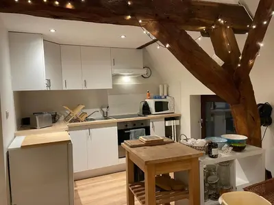 a kitchen with white cabinets and a table in it at Petit duplex cosy coup de coeur, dans ferme de charme du 18 è siècle au milieu des champs in Bossut-Gottechain