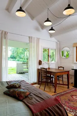 a bedroom with a table and a bed and a desk at Huisje aan de Vijver in Hamme