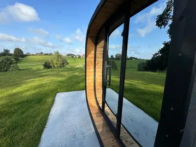 a glass door of a house with a view of a field at Vakantiewoning The View in Gooik