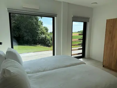 a bedroom with a bed and a large window at Vakantiewoning The View in Gooik