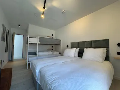 a bedroom with a large bed with white sheets at Vakantiewoning The View in Gooik