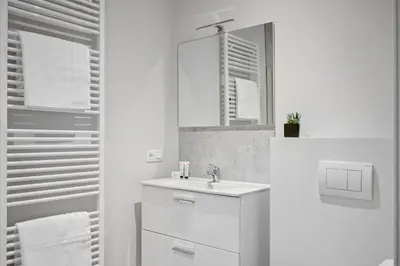 a white bathroom with a sink and a mirror at Imperiashortstay in Zaventem