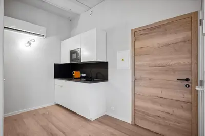 a room with a wooden door and a kitchen at Imperiashortstay in Zaventem