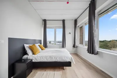 a bedroom with a bed and large windows at Imperiashortstay in Zaventem