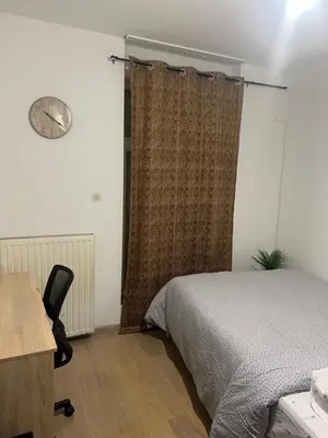 a bedroom with a bed and a desk and a clock at Brussels center city appartement in Brussels