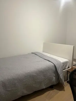a bed in a bedroom with a white wall at Brussels center city appartement in Brussels