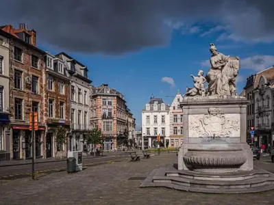 a statue in the middle of a city with buildings at Superbe appartement au coeur du Sablon in Brussels