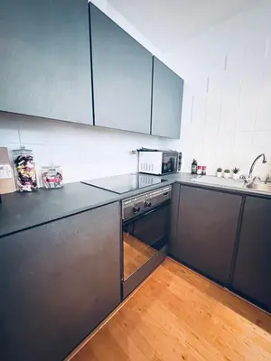 a kitchen with stainless steel appliances and a wooden floor at Superbe appartement au coeur du Sablon in Brussels