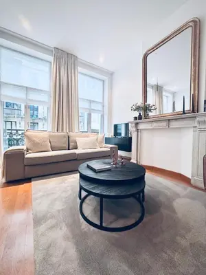 a living room with a couch and a table at Superbe appartement au coeur du Sablon in Brussels