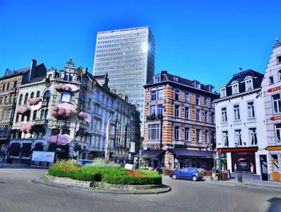 a city with tall buildings and a street with cars at Superbe appartement au coeur du Sablon in Brussels