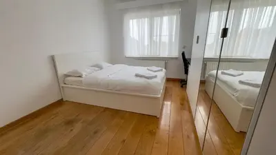 a white bedroom with a bed and a mirror at House with 5 bedrooms near Brussels in Wemmel