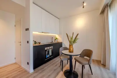 a living room with a table and chairs and a fireplace at Stay at Brussels in Brussels