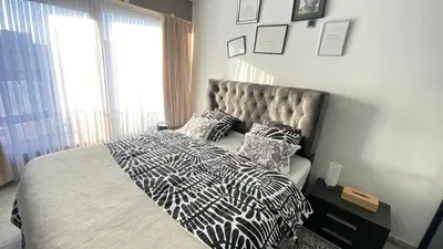 a bedroom with a bed with a black and white comforter at Strelitzyahouse in Brussels