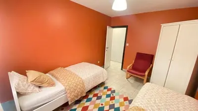 a bedroom with two beds and a red wall at Strelitzyahouse in Brussels