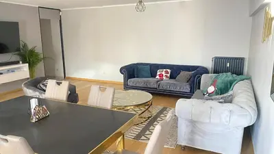 a living room with a couch and a table and chairs at Strelitzyahouse in Brussels