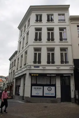 a man walking in front of a white building at Cozy Central Apartment with Cathedral View on the 3rd floor in Antwerp