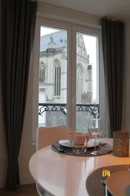 a table with a wine glass and a view of a building at Cozy Central Apartment with Cathedral View on the 3rd floor in Antwerp