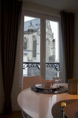 a table with a wine glass and a view of a building at Cozy Central Apartment with Cathedral View on the 3rd floor in Antwerp