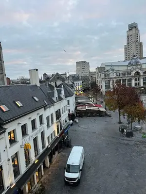 a white van parked in a parking lot in a city at Cozy Central Apartment with Cathedral View on the 3rd floor in Antwerp