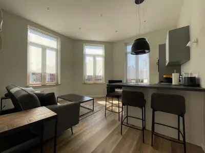 a kitchen and living room with a bar and chairs at Midi Station 2 in Brussels